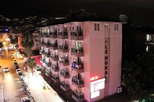 a pink building on a city street at night at Le Moral Apart Hotel in Alanya