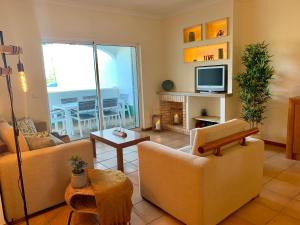 Sala de estar con 2 sofás y TV en Charming Apartment with Private Garden & Pool, en Vilamoura