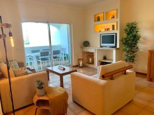 a living room with two couches and a television at Charming Apartment with Private Garden & Pool in Vilamoura