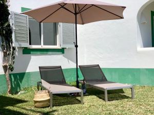 dos sillas y una sombrilla junto a un edificio en Charming Apartment with Private Garden & Pool, en Vilamoura