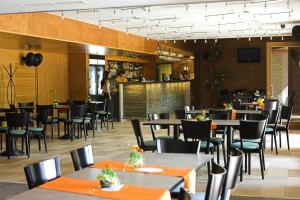 a restaurant with tables and chairs and a bar at Völgyikút Ház in Veszprém