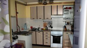 a kitchen with wooden cabinets and a white stove top oven at Guest House Sergey in Kolašin