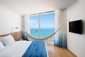 a bedroom with a bed and a view of the ocean at Hotel Arpoador in Rio de Janeiro