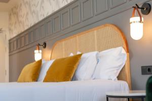 a bedroom with a bed with yellow and white pillows at Puente Colgante Boutique Hotel in Portugalete