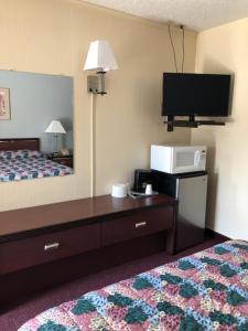 a hotel room with a bed and a flat screen tv at A1 Choice Inn in Mount Shasta