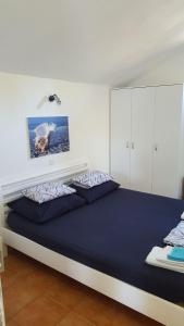 a bedroom with a large bed with blue sheets at House Ivan in Postira