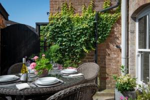 a table with chairs and plates on a patio at A Luxury Retreat in the Heart of Arundel in Arundel