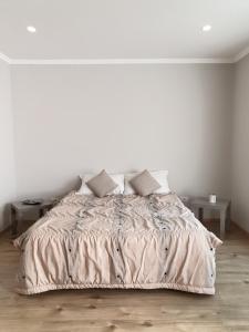 a white bedroom with a large bed with pillows at Villa 27 Residence in Tirana