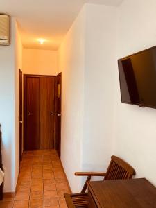 a hallway with a door and a television on a wall at Hotel Casa do Parque in Castelo de Vide