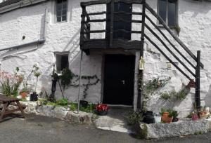 a white building with a black door and stairs at The Star Inn in Saint Erth