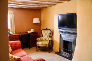 a living room with a fireplace with a tv on top of it at The Cottage Hotel in Nottingham