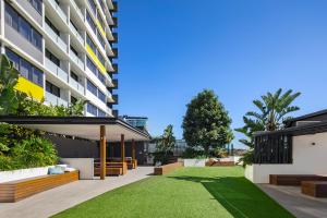 a grassy area with a large building at Alcyone Hotel Residences in Brisbane