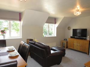 a living room with leather chairs and a television at Bradford Lodge - Close to Hospital in Mile End