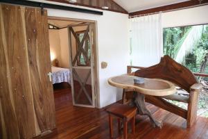 Habitación con mesa de madera y puerta en Caribbean Secret en Cahuita