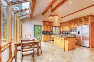 a kitchen with wooden cabinets and a table and chairs at Sucia Island Mountain View in Eastsound