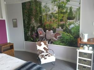 a bedroom with a view of a garden at Te Aputa Lodge formerly La Casa Te Puru Lodge in Te Puru