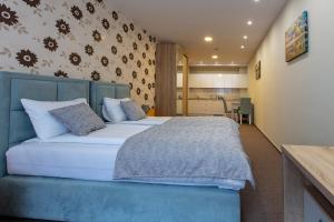 um quarto com uma cama azul e uma cozinha em Hotel IUT em Travnik