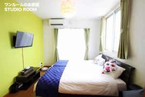 a hotel room with a bed and a window at Chura Minpaku Ishigaki in Ishigaki Island
