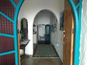 a hallway in a house with a blue doorway at La Casa Te Puru Lodge in Te Puru