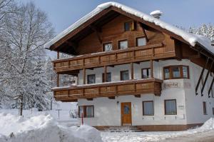 Une grande maison en bois recouverte de neige dans l'établissement Gruggerhof, à Seefeld in Tirol