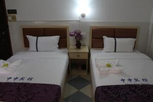 2 Betten nebeneinander in einem Zimmer in der Unterkunft Don Bosco Guesthouse in Sihanoukville