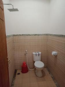łazienka z toaletą w kabinie wyłożonej kafelkami w obiekcie Riung Guesthouse w mieście Riung