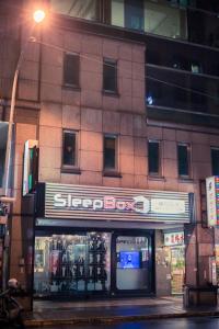 a store front of a building with a sign on it at SleepBox Hostel in Taipei