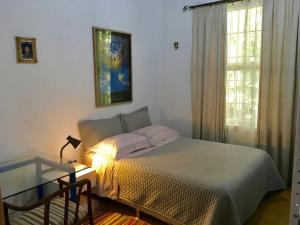 a bedroom with a bed with a lamp and a window at Residência Acolhedora in Porto Alegre