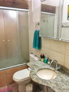 een badkamer met een toilet, een wastafel en een douche bij Residência Acolhedora in Porto Alegre