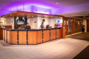 eine Lobby mit zwei Personen, die an einer Theke stehen in der Unterkunft Copthorne Hotel Auckland City in Auckland