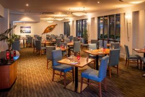 um restaurante com mesas e cadeiras num quarto em Copthorne Hotel Auckland City em Auckland