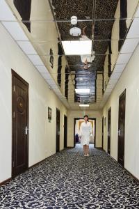 a woman walking down a corridor in a hallway at Hotel Chalpan in Abakan