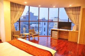 a hotel room with a bed and a large window at Ngoại Thương Hotel Từ Sơn Bắc Ninh in Bình Ha
