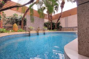 a swimming pool with palm trees around it at Q Motel in Tucheng