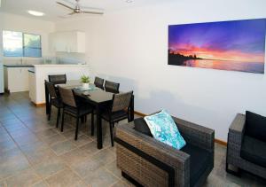 a living room filled with furniture and a table at Cable Beach Apartments in Broome