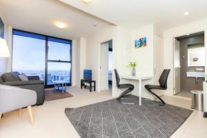 a living room filled with furniture and a large window at Melbourne SkyHigh Apartments in Melbourne