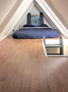 a bedroom with a bed and a wooden floor at Oxford Tiny House in Oxford