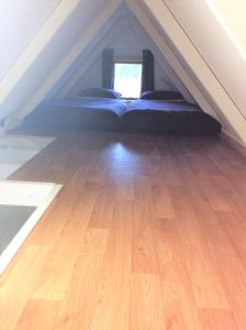 um quarto com uma cama no sótão e piso em madeira em Oxford Tiny House em Oxford