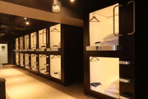 a row of display cases in a room with mirrors at ビジネスカプセルホテル Lightning Hotel浅草 in Tokyo