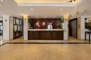 two people standing at a bar in a lobby at Hong Ngoc Cochinchine Boutique Hotel & Spa in Hanoi