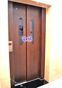 uma porta de madeira com sinais numa sala em Forest Deer Black Tea Homestay em Tainan
