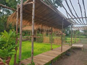 um pavilhão com um telhado de relva e um deque de madeira em Supalai Pasak Resort Hotel And Spa em Kaeng Khoi