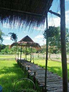 einen Weg, der zu einer Hütte auf einem Feld führt in der Unterkunft Supalai Pasak Resort Hotel And Spa in Kaeng Khoi