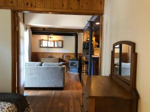 a living room with a couch and a mirror at Chalets et Studios Le Vent Du Nord in Lac-Superieur +90 photos