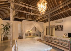 a dining room with a table and a bed at Aloha Beach House Bingin in Uluwatu