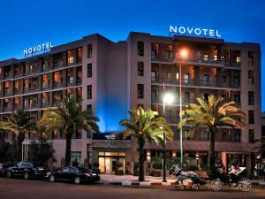 a horse drawn carriage in front of a hotel at Novotel Marrakech Hivernage in Marrakech