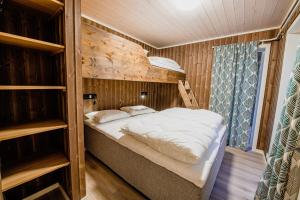 a bed in a room with a wooden wall at Lakeside Haven Vrådal in Vradal