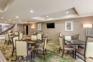 a restaurant with tables and chairs and a flat screen tv at Quality Suites Sherman in Sherman