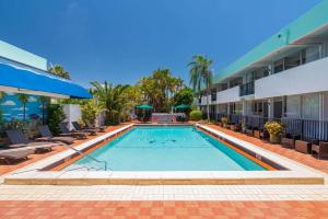 a swimming pool at a hotel with chairs and a building at Quality Inn Miami South in Kendall