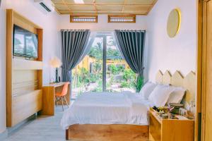 a bedroom with a bed and a large window at Binh Minh Eco Lodge in Can Tho